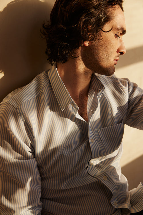 man wears a merino wool linen summer shirt from Wolk with chest pocket and light blue bengal stripe with white buttons
