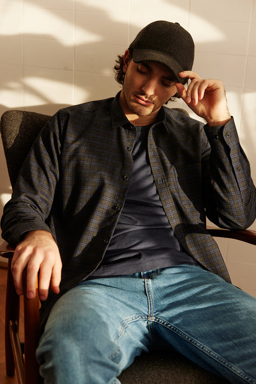Man sits down in a chair with merino wool flannel