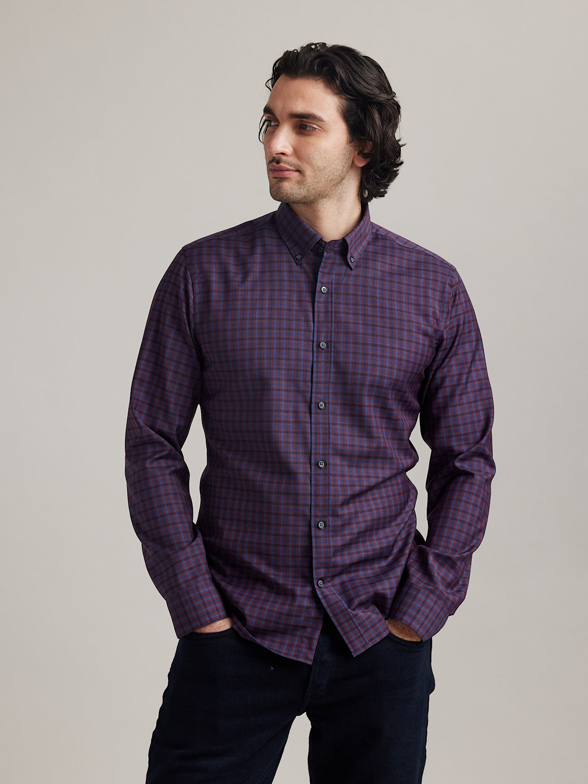 Man wears button down Alex merino wool shirt with checks in burgundy and navy colors in slim fit
