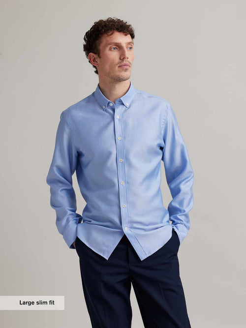 Man wears a Wolk merino wool shirt in Oxford fabric, button-down collar in light blue with white buttons in slim fit