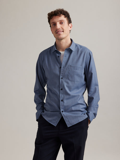 man wearing a 100% merino wool shirt with chest pocket in navy blue  with white merino wool T-shirt underneat