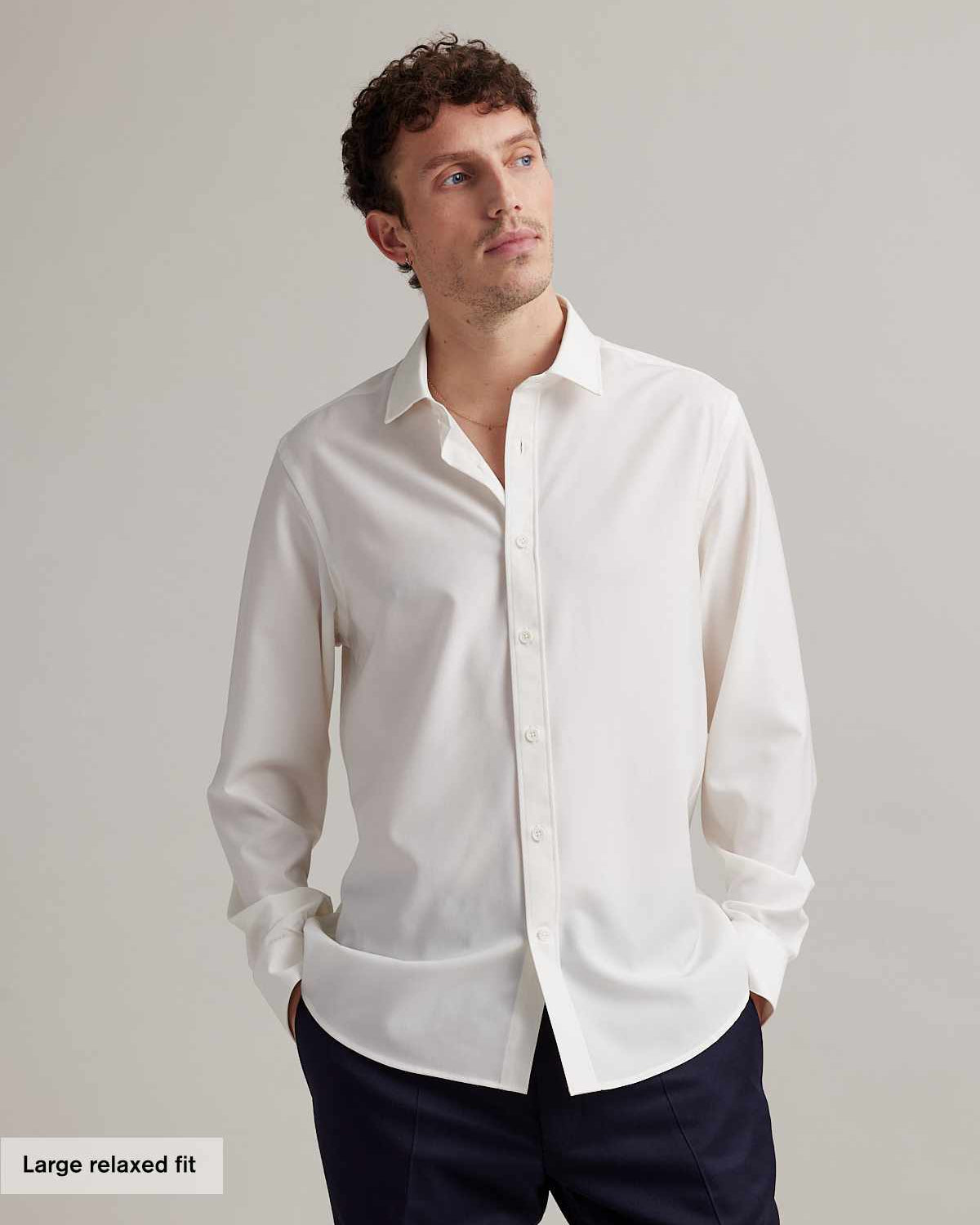 Man wears a relaxed fit white merino formal shirt in 100% merino wool from Wolk