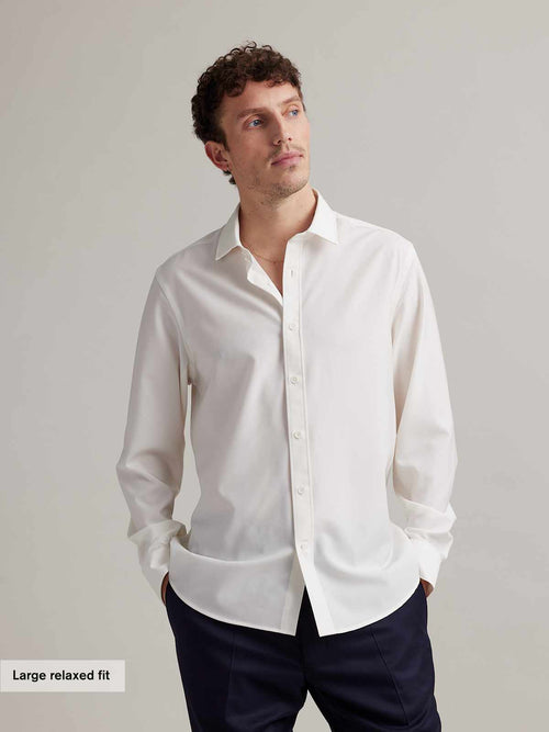 Man wears a relaxed fit white merino formal shirt in 100% merino wool from Wolk