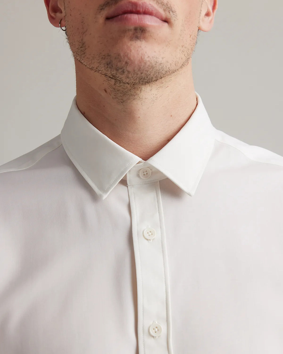 A close up of white merino wool dress shirt with classic collar and corozo buttons in white from the brand Wolk