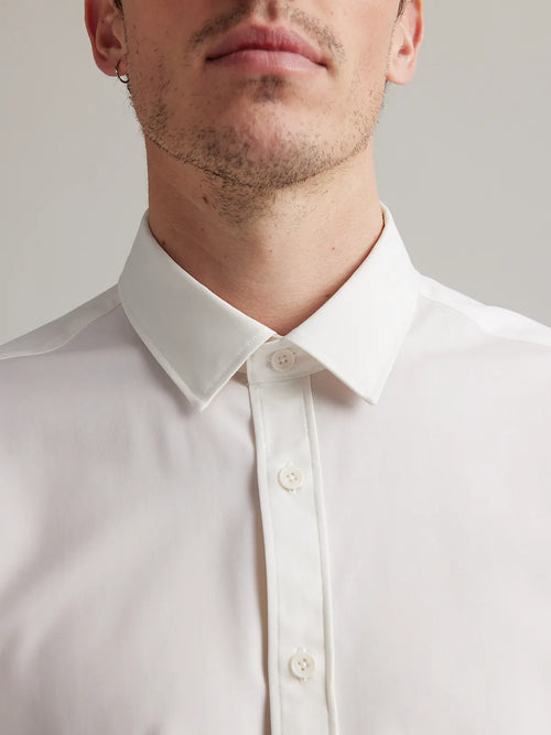 A close up of white merino wool dress shirt with classic collar and corozo buttons in white
