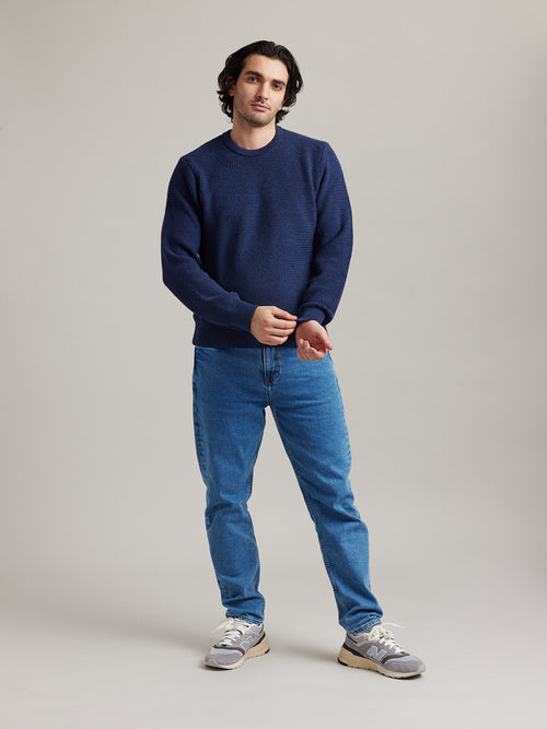man wearing merino wool sweater of wolk antwerp in navy blue color warm