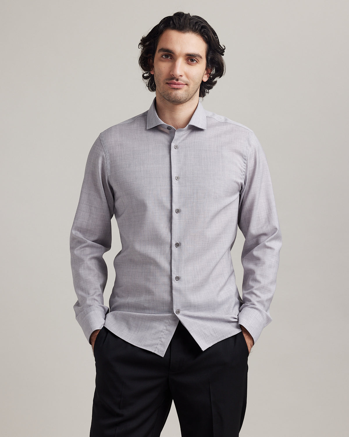 Man wears a grey melange merino wool shirt of Wolk in 100% merino wool with spread collar