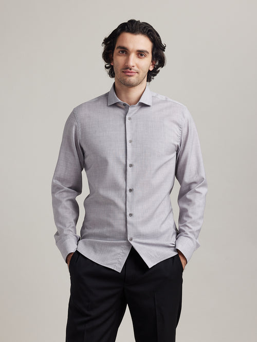 Man wears a grey melange merino wool shirt of Wolk in 100% merino wool with spread collar