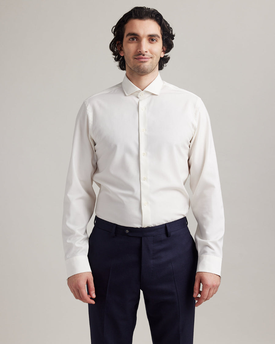 Man wears white merino shirt with long sleeves and spread collar with white buttons
