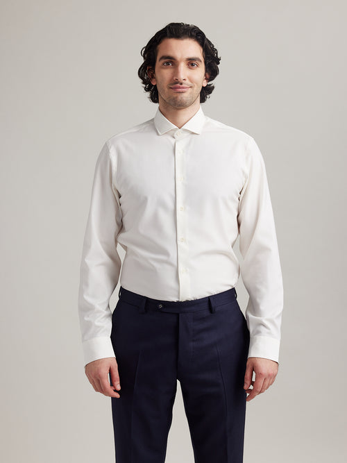 Man wears white merino shirt with long sleeves and spread collar with white buttons