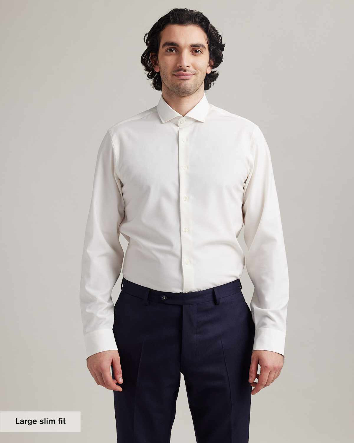 Man wears white merino shirt with long sleeves and spread collar in slim fit
