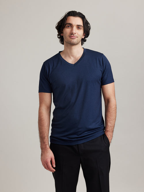 Man wears a merino wool T-shirt with V neck collar in navy color and short sleeves