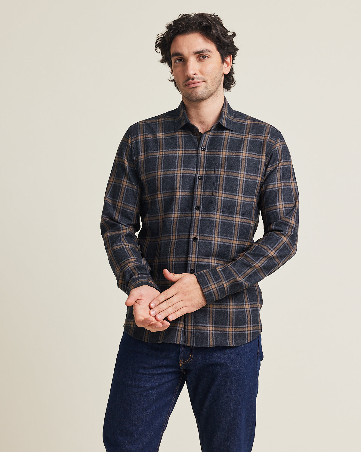 Man wears a merino wool flannel warm winter shirt from Wolk in grey brown plaid pattern with chestpocket