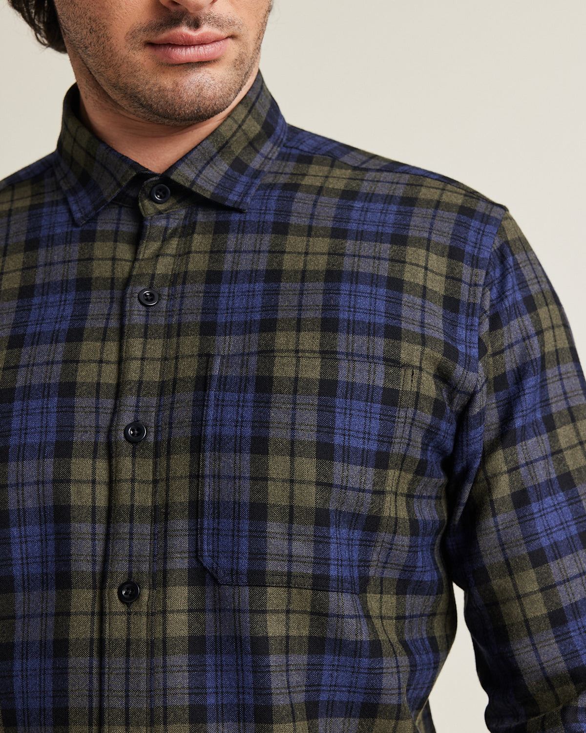 Close up of merino wool flannel shirt with chest pocket in green navy check pattern