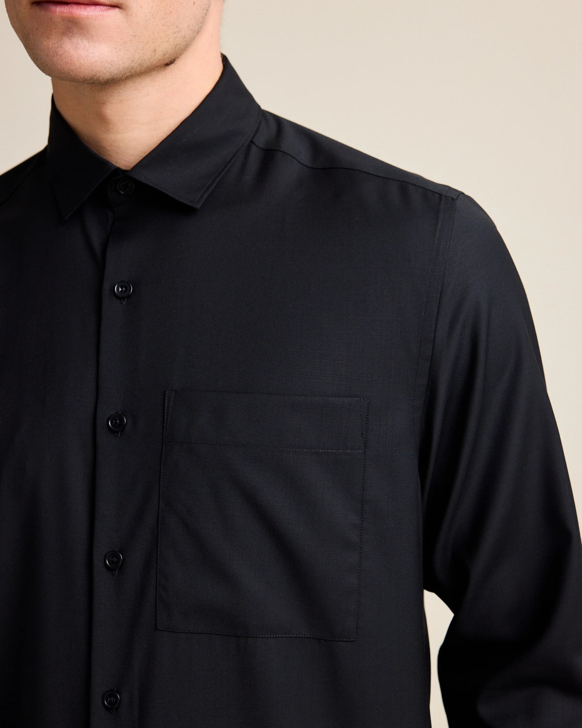 Merino wool shirt with long sleeves and chest pocket in black color and relaxed wide fit.