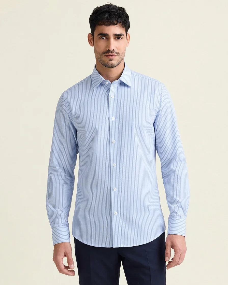 Man wearing a light blue striped merino shirt against a beige background