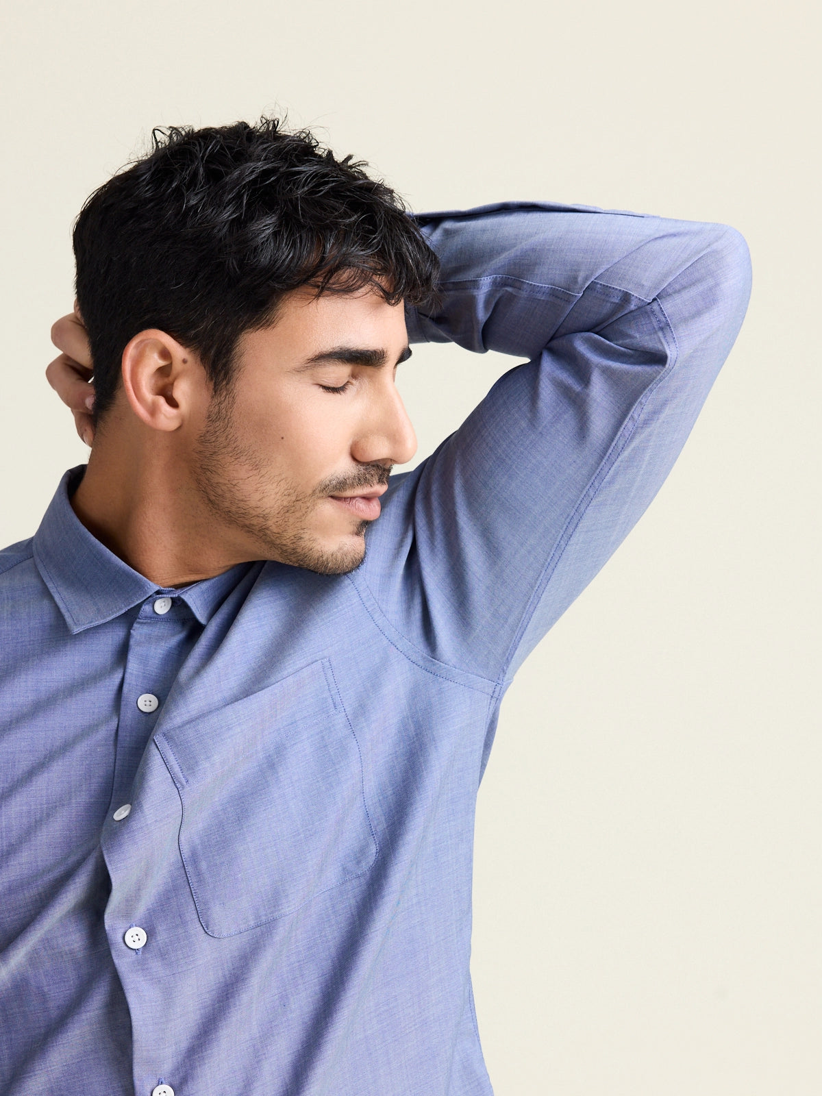 Man smells his odour resistant merino wool shirt in light blue denim color with chest pocket from the brand Wolk