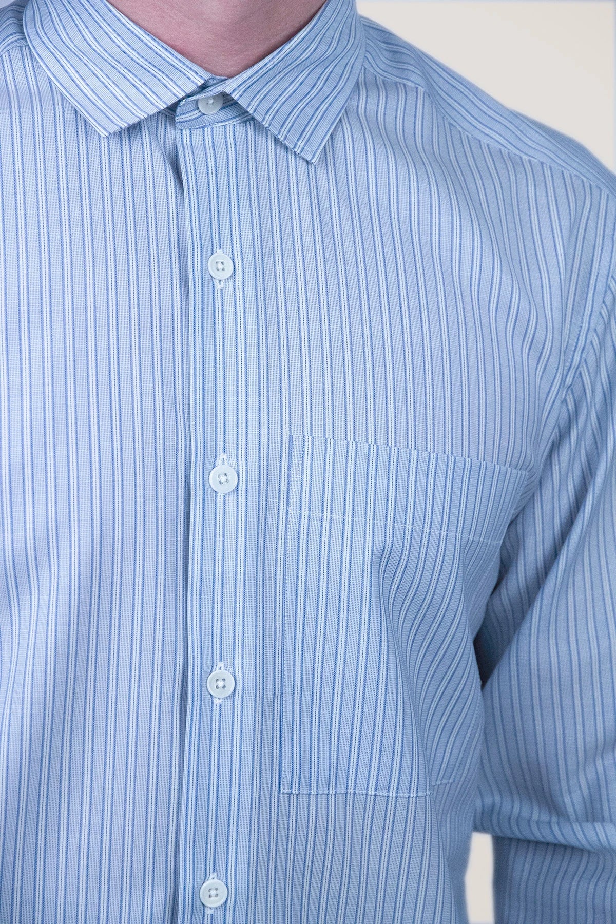 Close-up of a blue striped merino shirt with a collar and buttons.