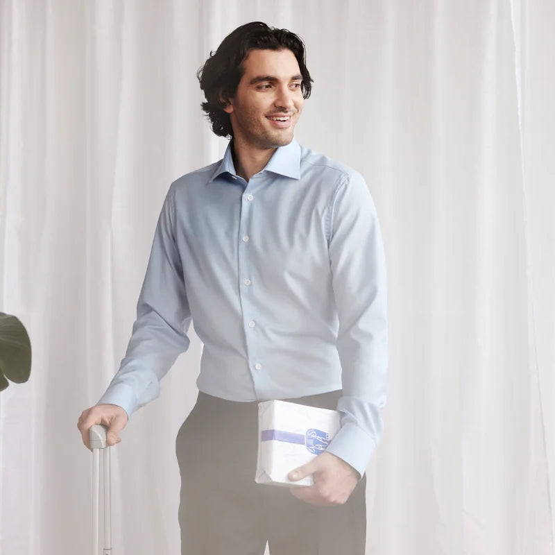 Man arriving home from business trip in a light blue merino wool shirt from Wolk