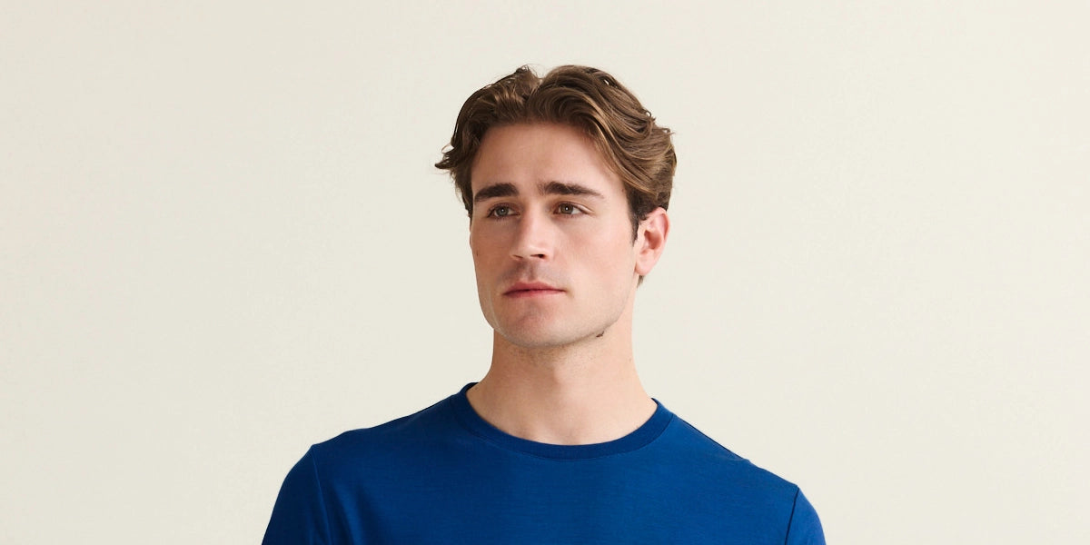 man wears a blue merino t-shirt with short sleeves with crew neck in 17,5 micron merino yarn