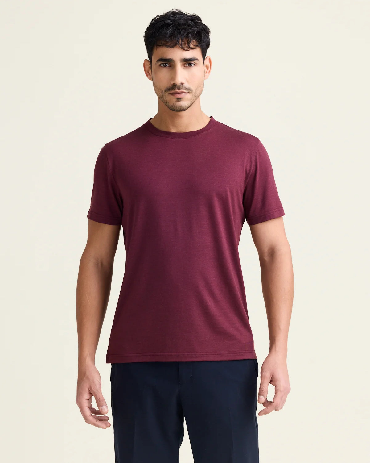 Man wears burgundy merino wool T-shirt with crew neck and short sleeves from Wolk.
