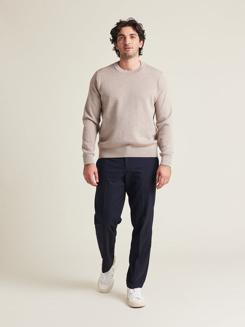Man wears a responsible merino wool sweater knit in superfine 100% merino wool in taupe color