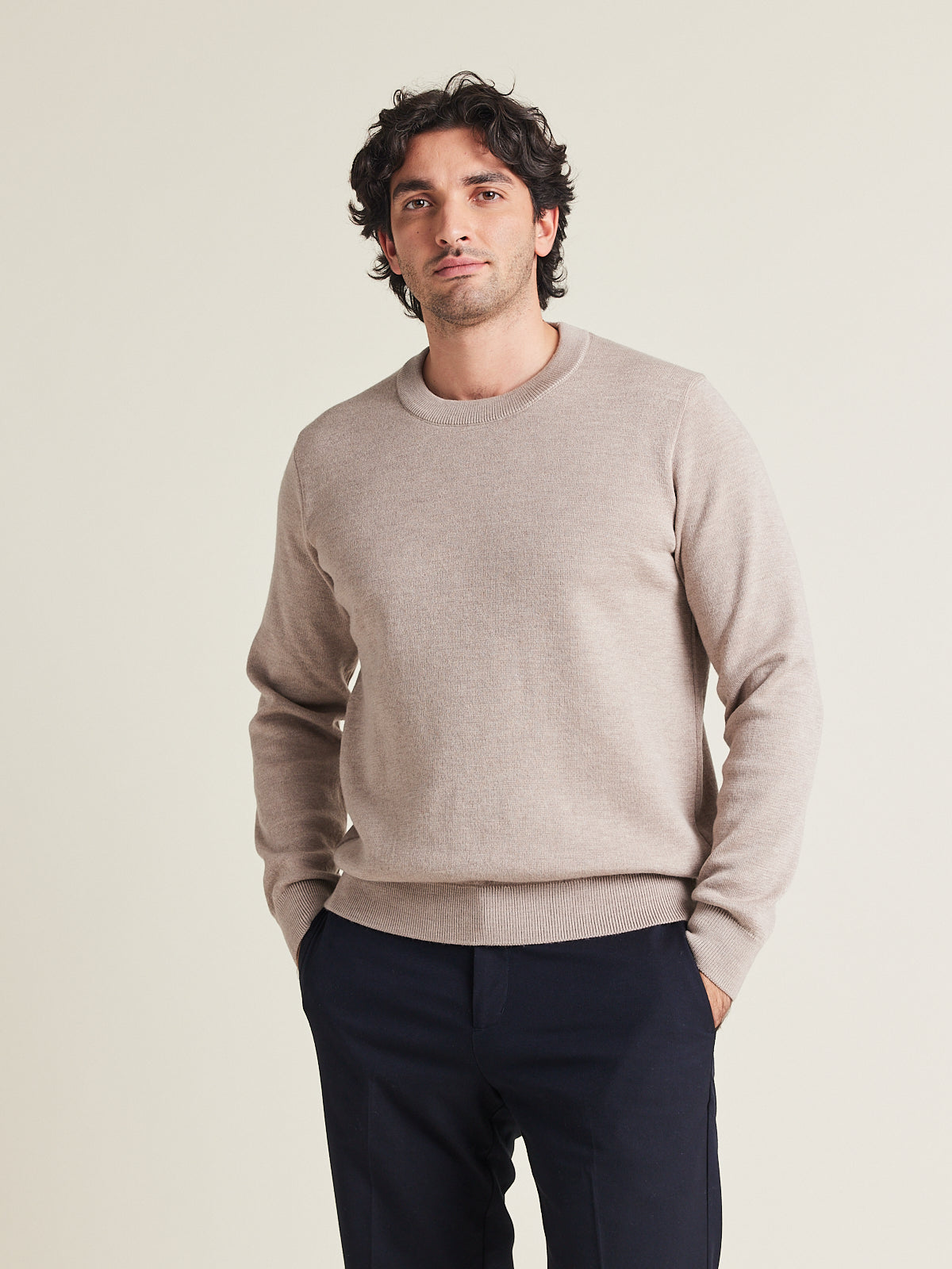 Man wears 100% superfine merino wool pullover in taupe color with round collar on a navy pants from Wolk made in Portugal