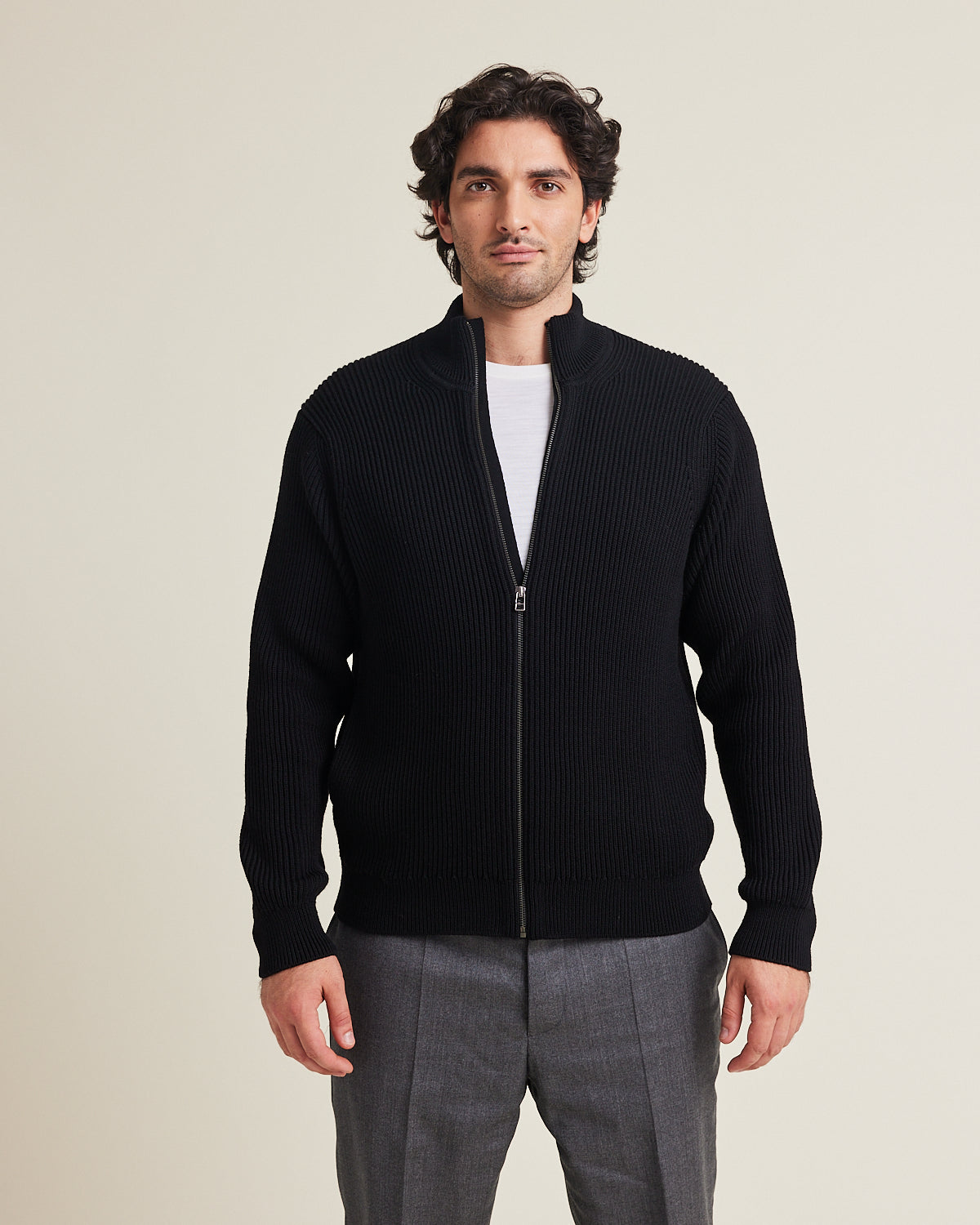 Man wears a full zip merino wool cardigan in black color and sidepockets from Wolk