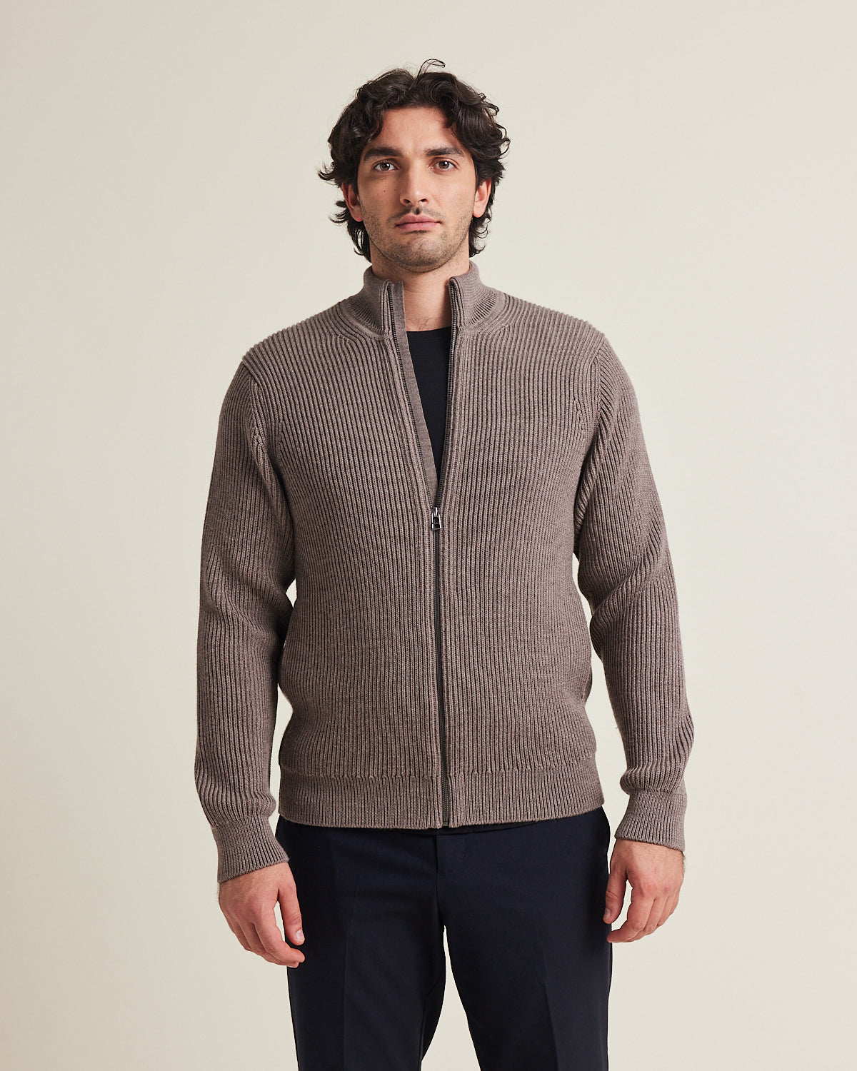 Man wears a haf zip merino wool sweater. in heavy weight warm with side pockets and high collar in brown color made in Portugal