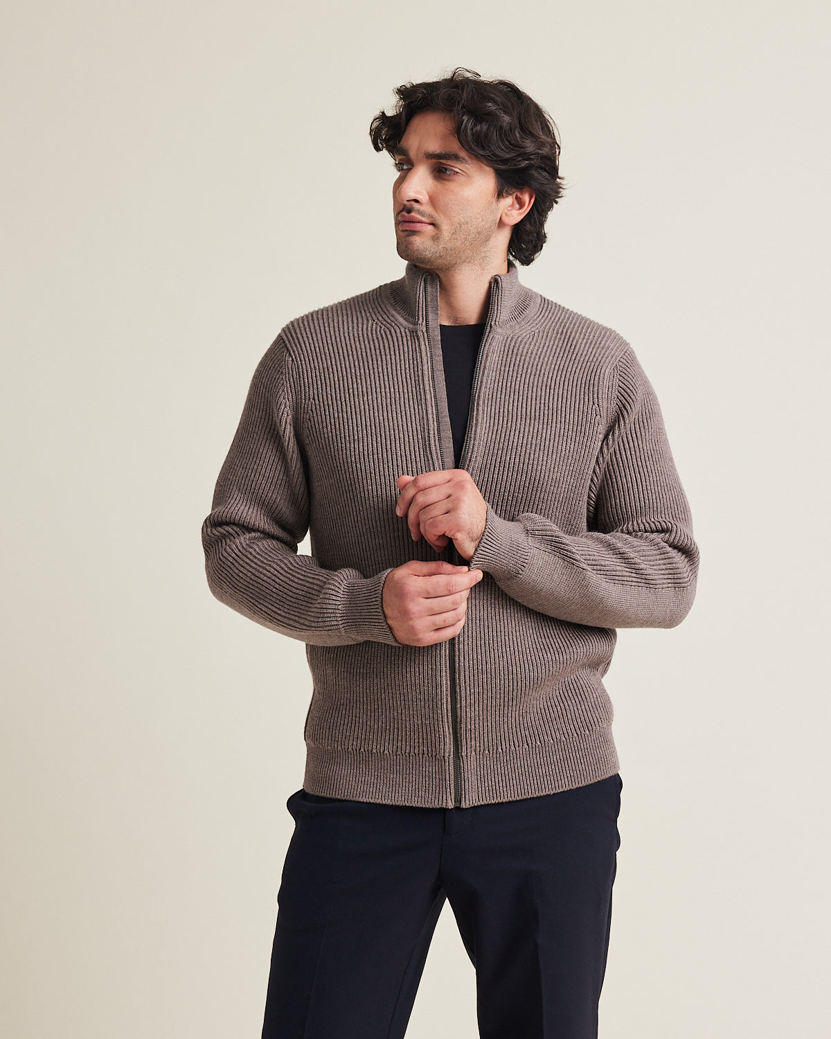 Man wears a haf zip merino wool sweater. in heavy weight warm with side pockets and high collar in brown color made in Portugal with 100% responsible merino wool