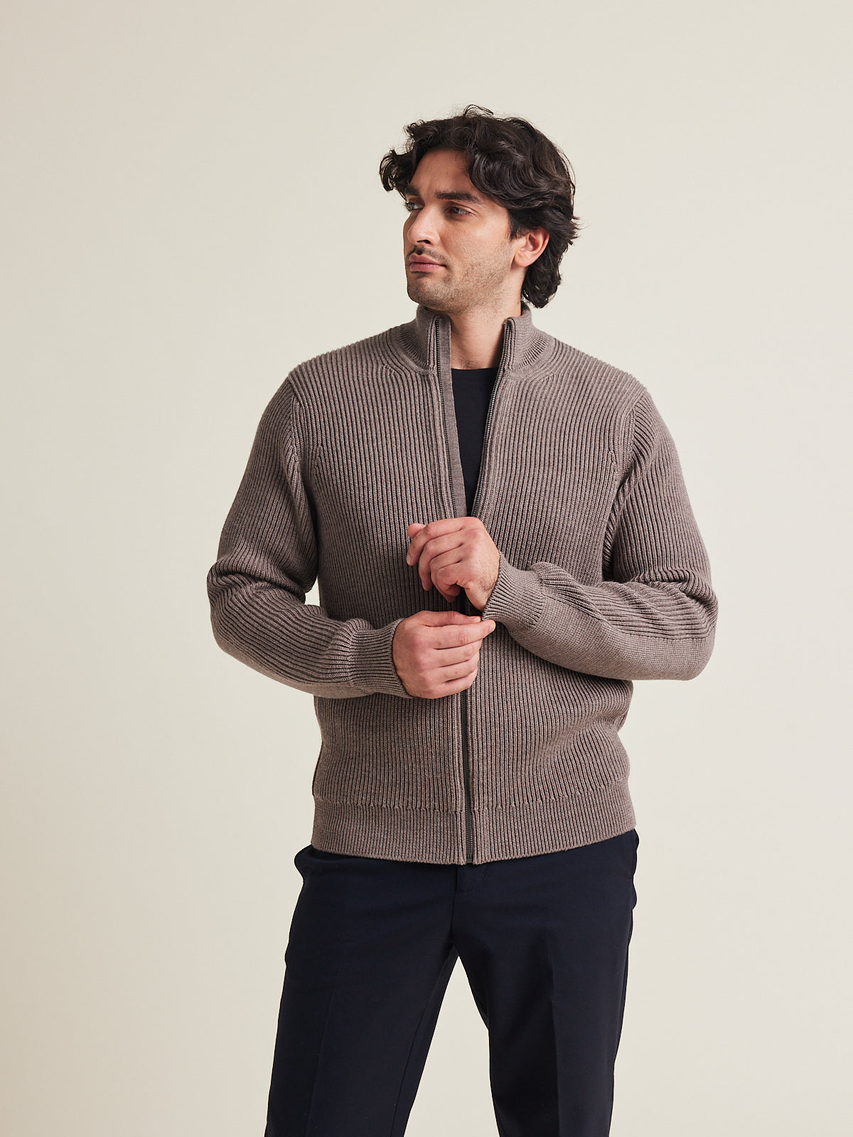 Man wears a haf zip merino wool sweater. in heavy weight warm with side pockets and high collar in brown color made in Portugal with 100% responsible merino wool
