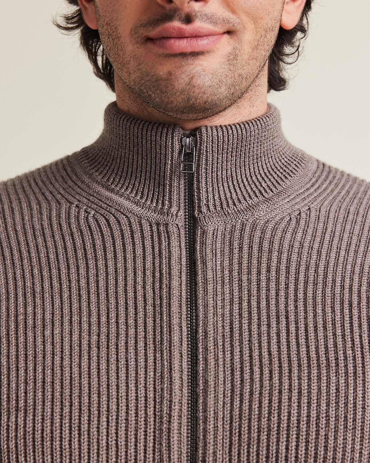 Close up of high collar zipped sweater in brown color and cardigan knit structure from Wolk