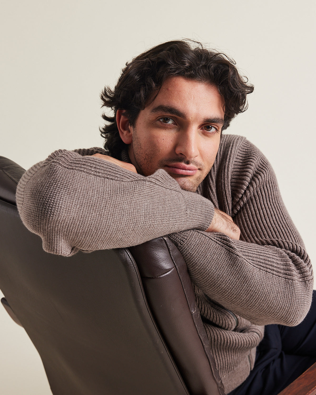 Man wears a merino wool full zip cardigan with reïnforced elbows and high collar in brown color winter warm