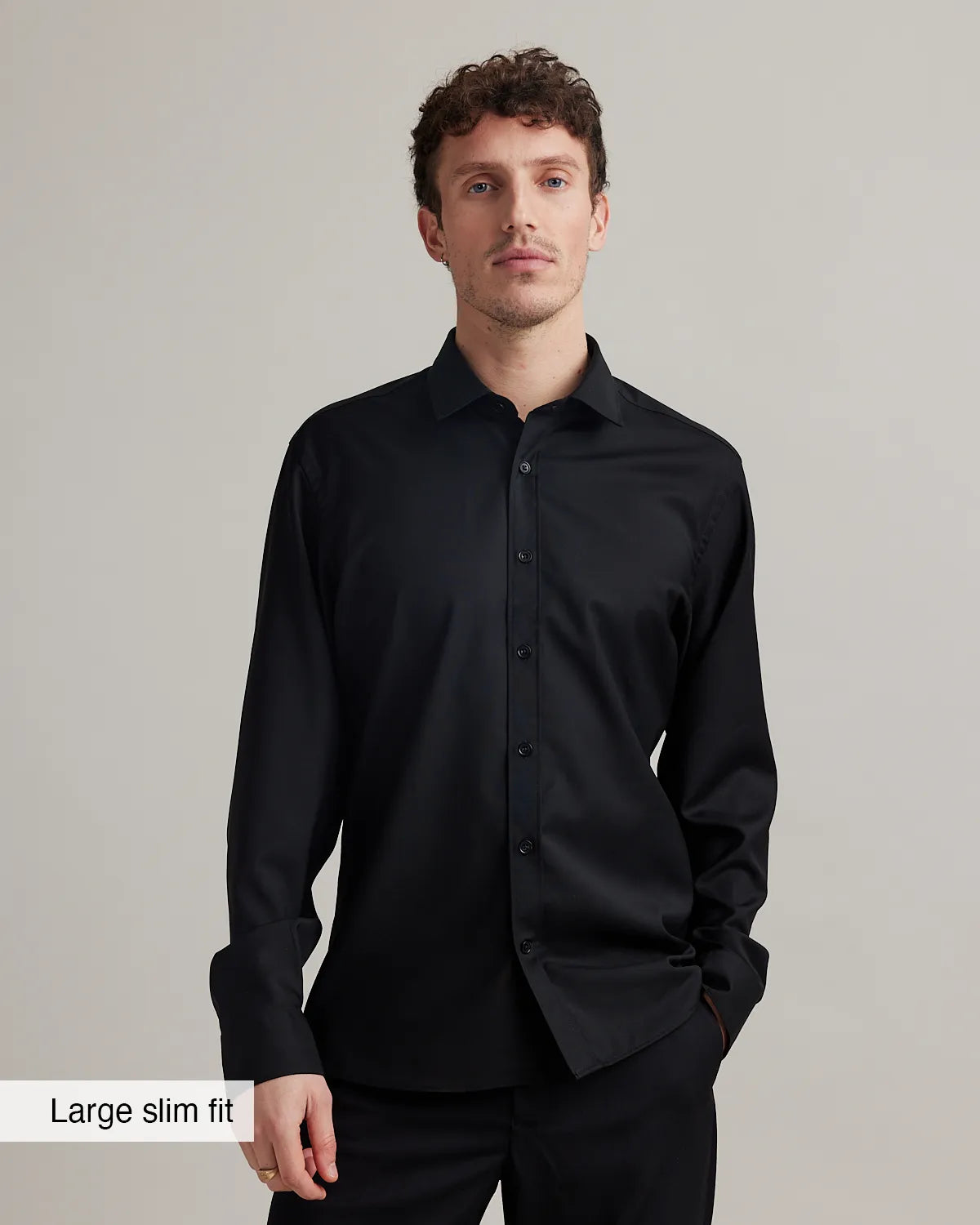 Man wearing a black merino dress shirt in slim fit on a plain background