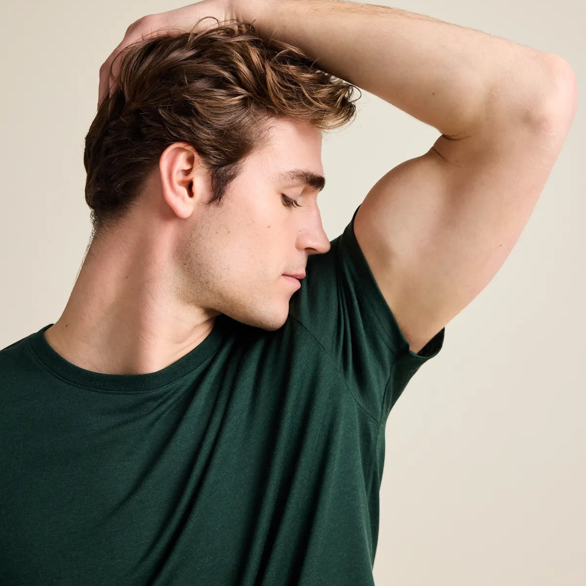 model smelling his armpit in a dark green merinowool T-shirt from Wolk