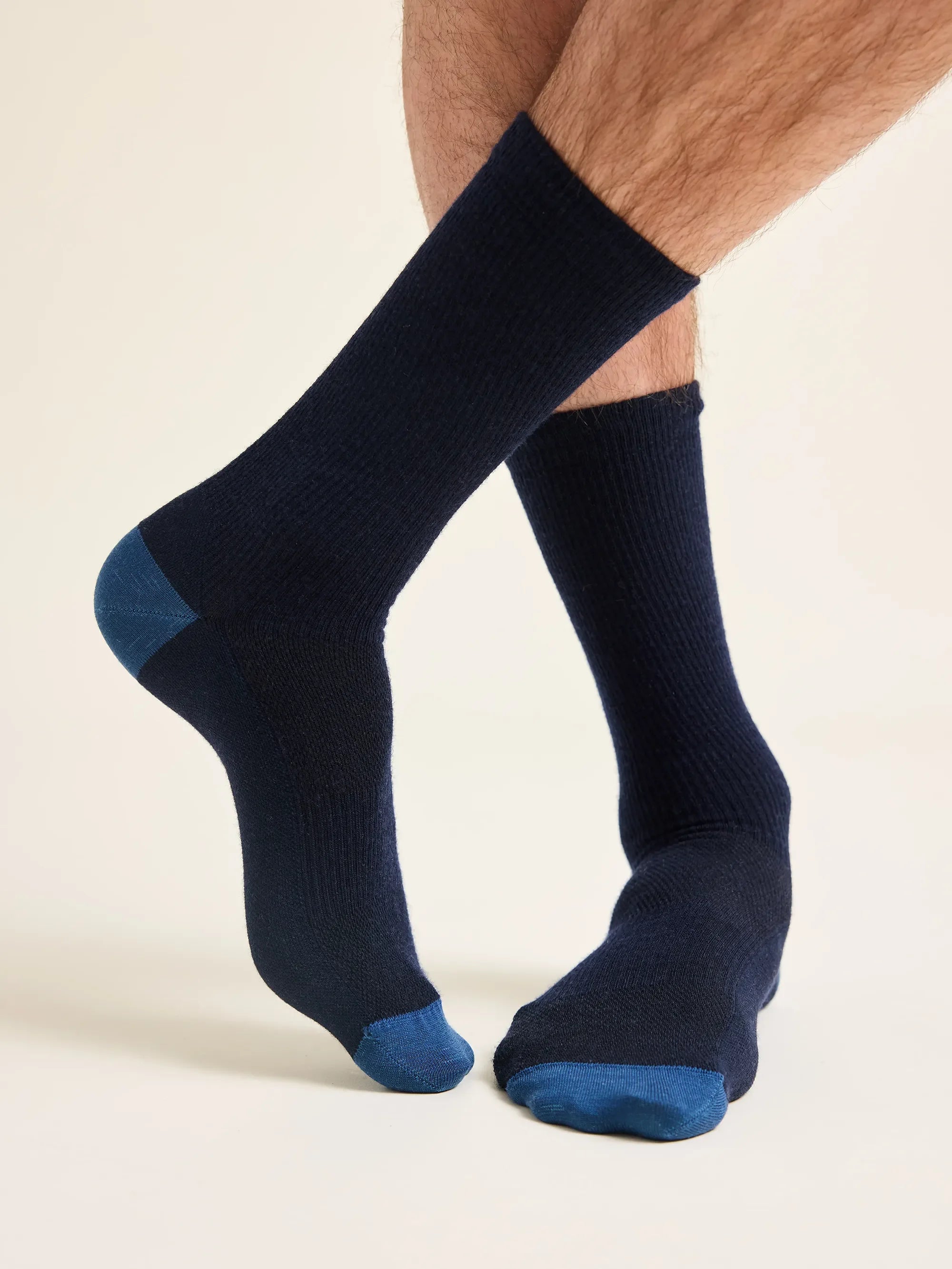 mid-high navy merino wool socks with blue toes and cuffs worn by a man