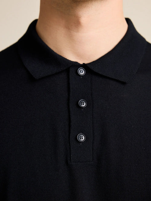 Détail du col du polo en merino noir pour hommes de la marque européenne Wolk.