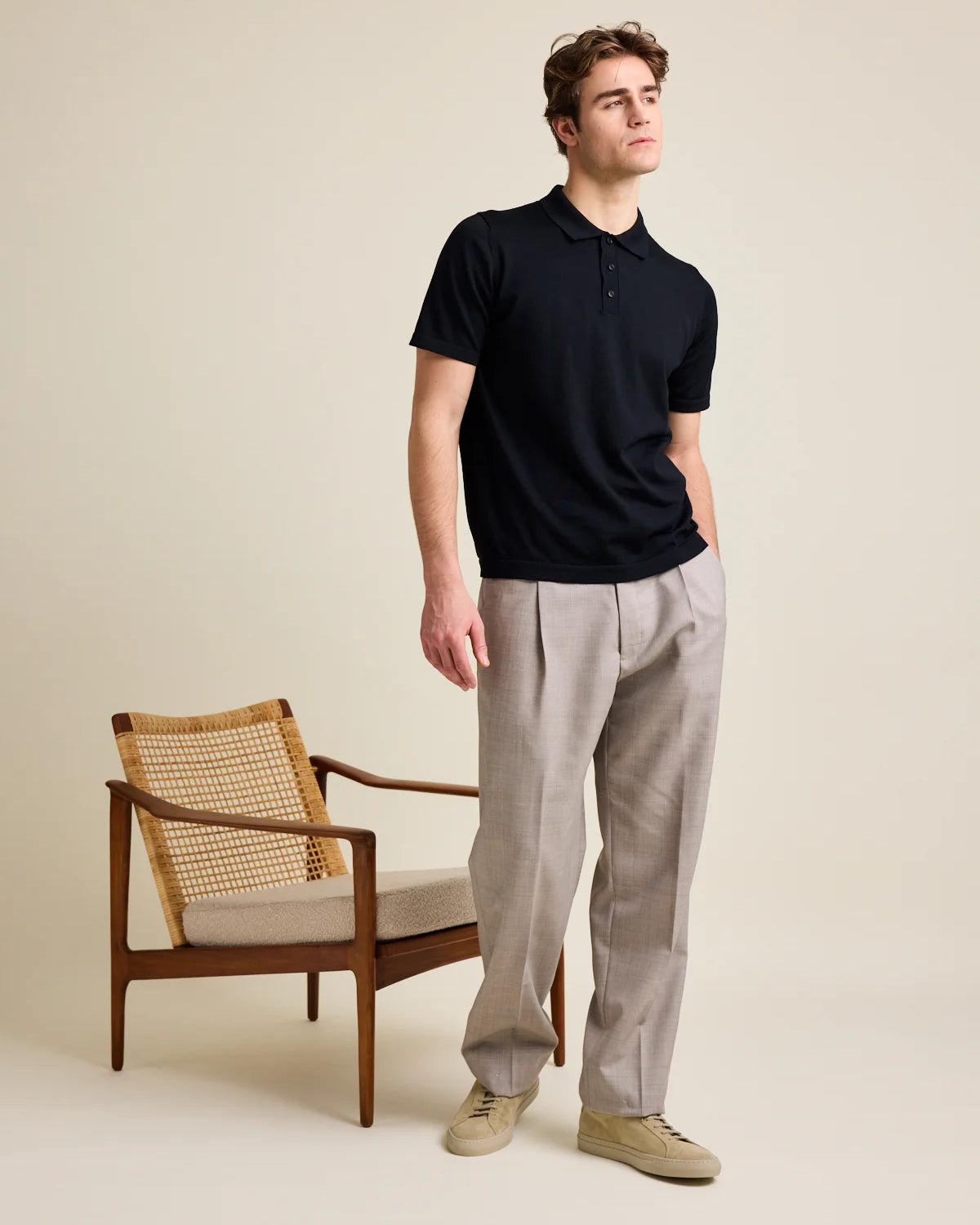 Studio shot of a men's black merino wool polo shirt from Wolk, highlighting its soft Cashwool surface.