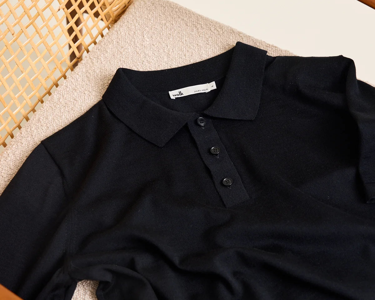 Wolk knitted merino wool polo in black with buttoned collar and short sleeves. Made from Cashwool yarn.