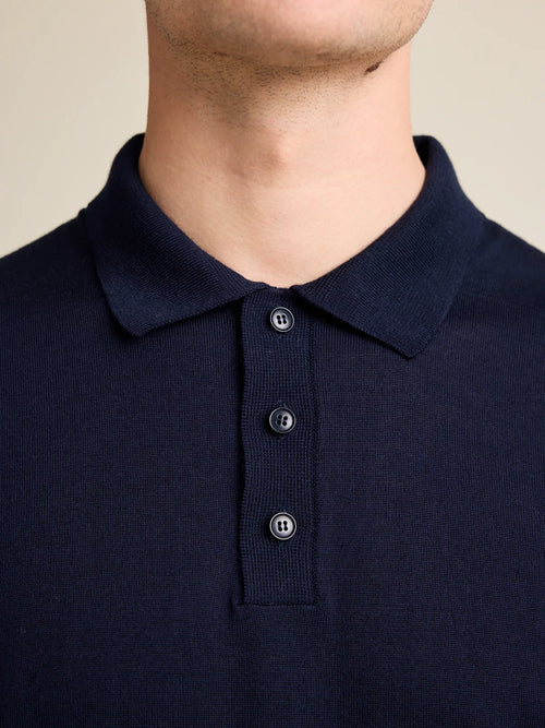 Détail du col en tricot d'un polo en laine mérinos en tricot bleu marine, avec 3 boutons corozo.