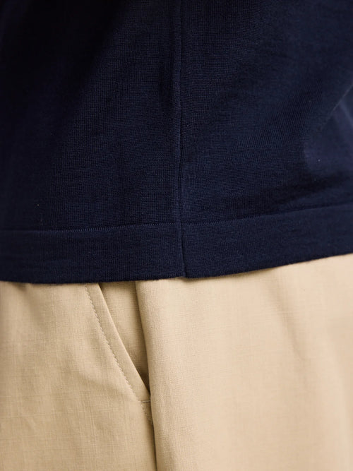 Détail du tricot de côtes sur l'ourlet d'un polo en laine mérinos en couler marine, de la marque européenne Wolk, présentant la qualité Cashwool de Zegna Baruffa.