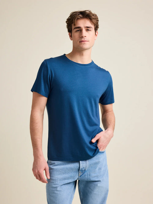 Wolk's denim blue colored men's merino wool T-shirt in a studio setting, showcasing crew-neck design.