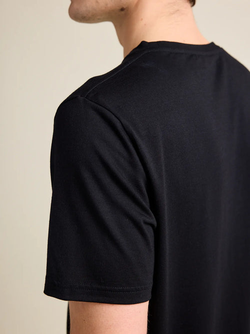 Shoulder detail of a men’s merino wool T-shirt with short sleeves in black from the Wolk Brand.