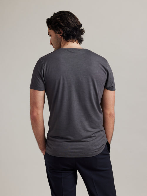 Studio shot of the back of a men's merino wool T-shirt in dark grey, designed by Wolk.