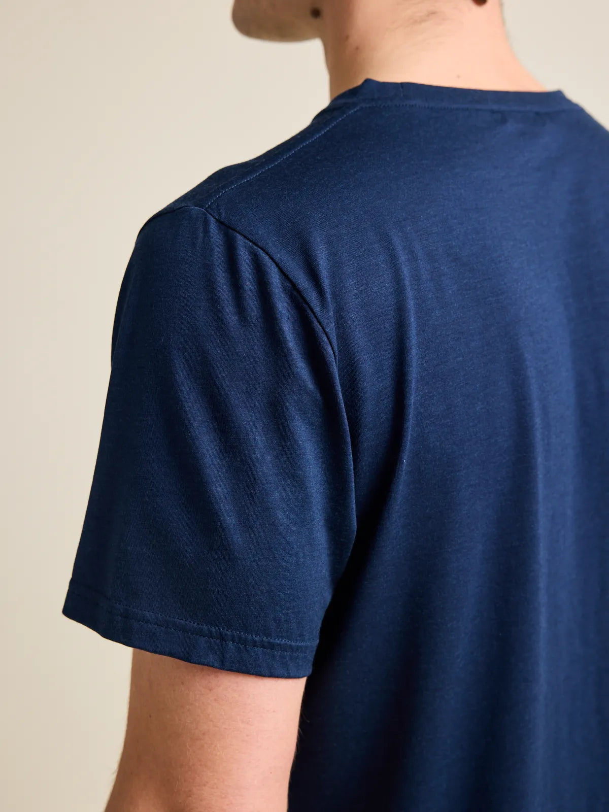 Detail shot of short sleeves of a men's dark navy blue merino wool T-shirt from Wolk, emphasizing the craftmenship