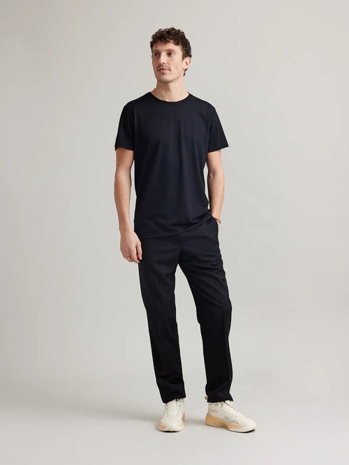 Studio shot of a men's light black merino wool T-shirt from Wolk, displaying the front profile and sleek design.