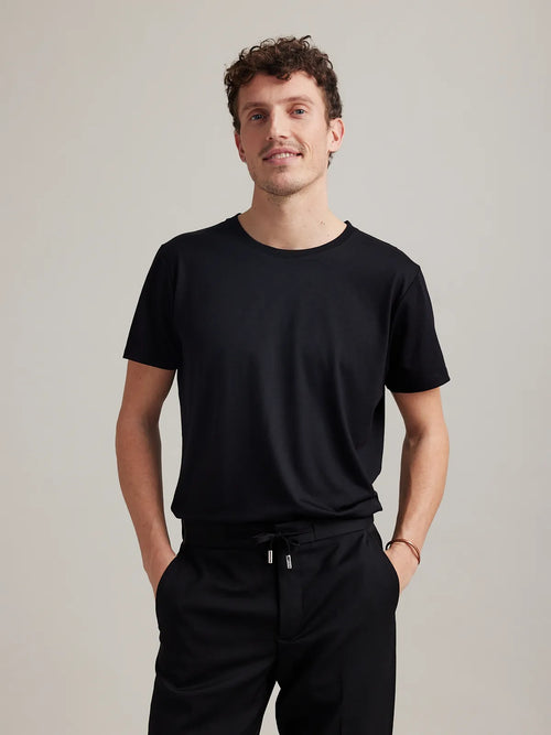 Wolk's light black men's merino wool T-shirt in a studio setting, showcasing crew-neck design.