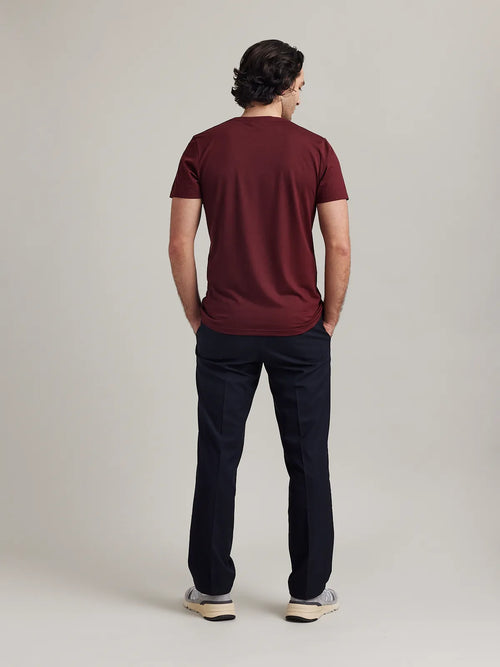 Back view of a male model wearing a burgundy merino wool T-shirt from the Wolk brand.