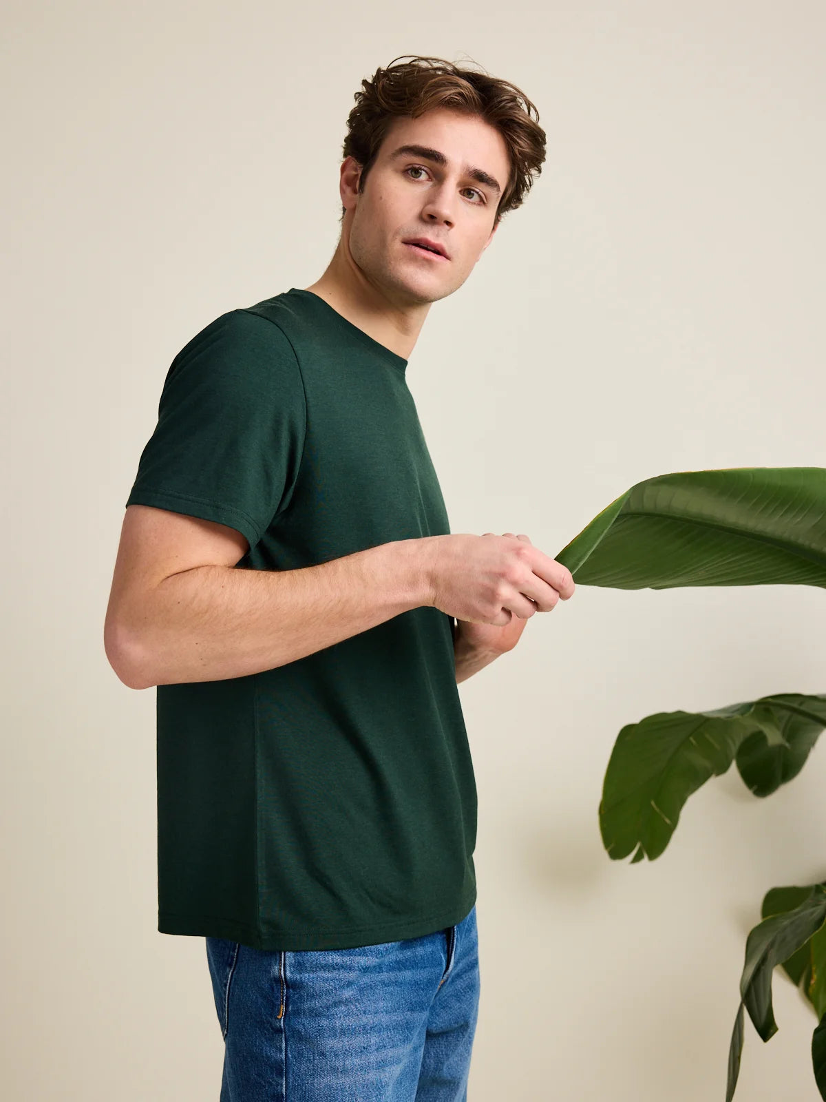 Man wears dark green merino wool T-shirt with crew neck and short sleeves from Wolk.