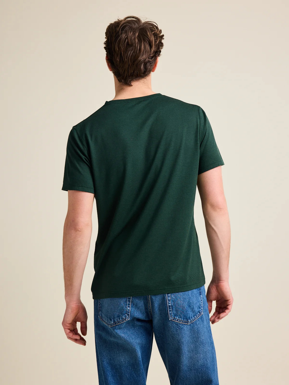 Men's dark green merino wool T-shirt from Wolk, back view highlighting the smooth texture and European craftsmanship.